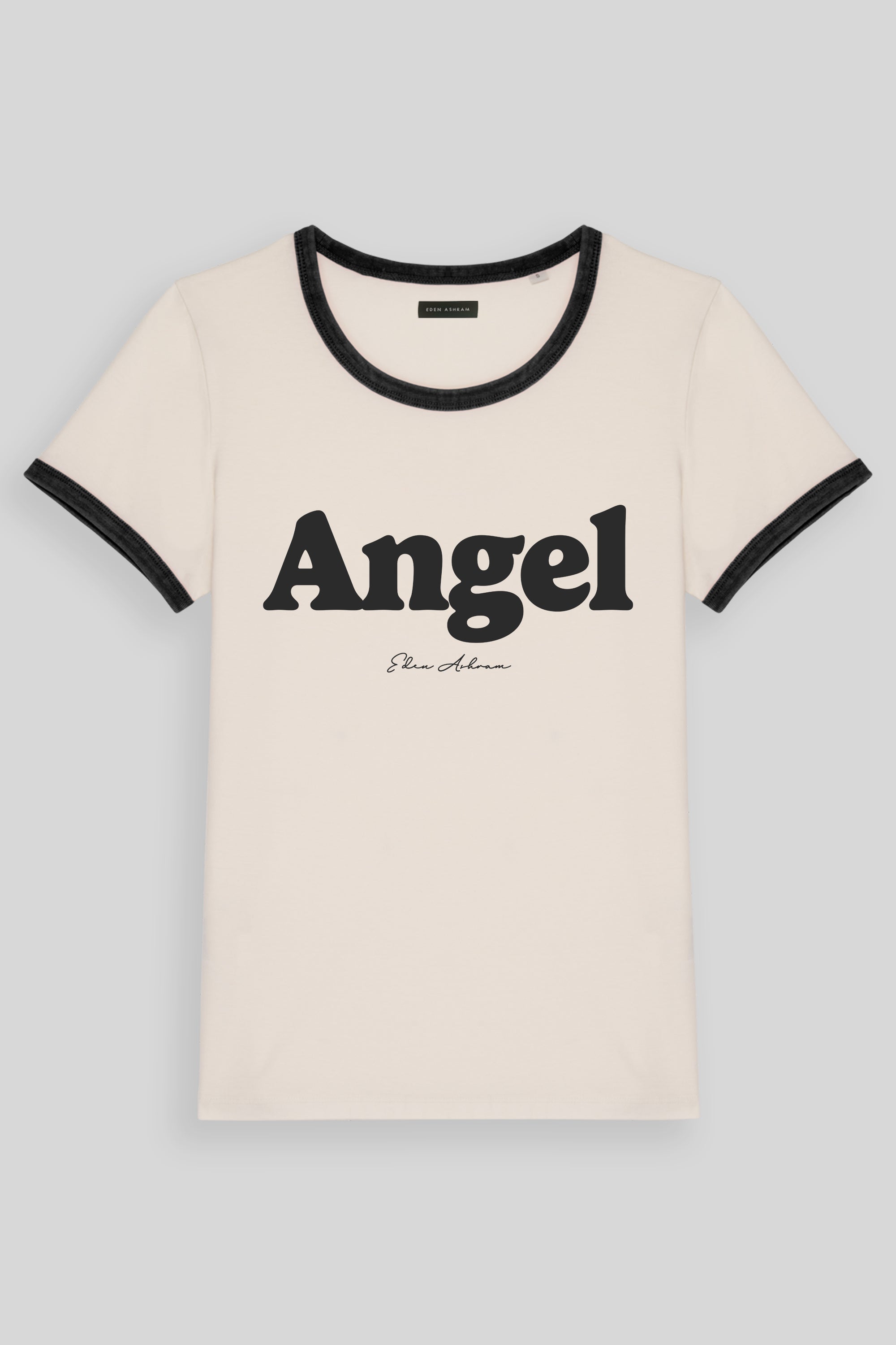 An off-white ringer t-shirt with black trim on the crew neck and sleeve cuffs, featuring the word 'Angel' printed in bold black letters across the chest, with 'Steve Madden' in cursive underneath.